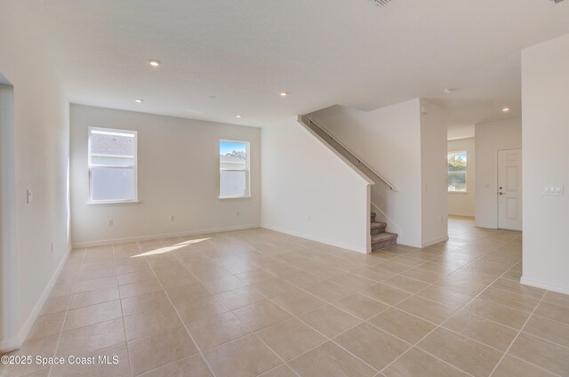 3265 Viridian Cir, West Melbourne, FL 32904 - unfurnished living room featuring light tile patterned floors, plenty of natural light, stairs, and recessed lighting