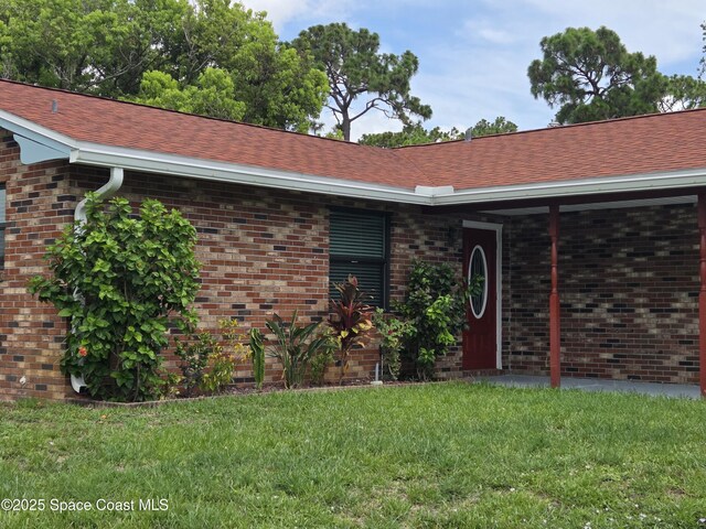 744 John Carroll Ln, Melbourne, FL 32904 - view of front of property featuring a front yard, brick siding, and roof with shingles