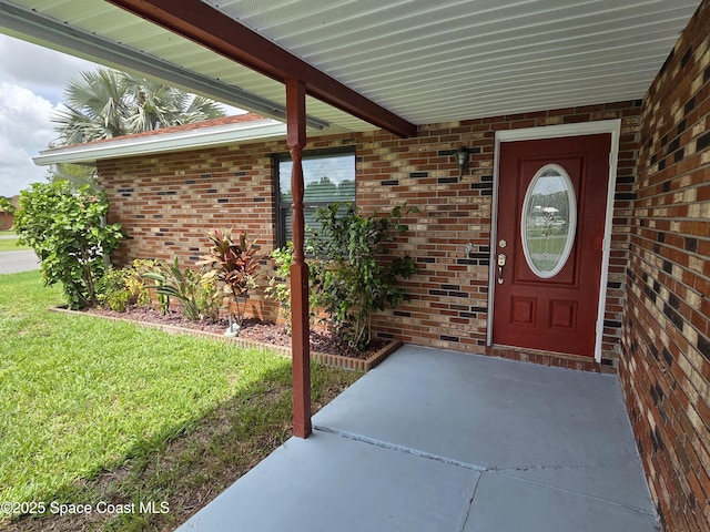 744 John Carroll Ln, Melbourne, FL 32904 - doorway to property featuring brick siding and a lawn