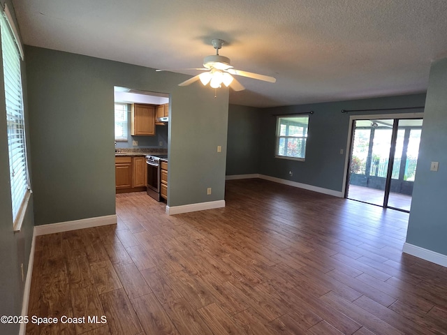 744 John Carroll Ln, Melbourne, FL 32904 - unfurnished living room featuring dark wood finished floors, a ceiling fan, and a textured ceiling