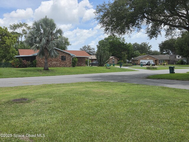 744 John Carroll Ln, Melbourne, FL 32904 - view of grassy yard with curved driveway