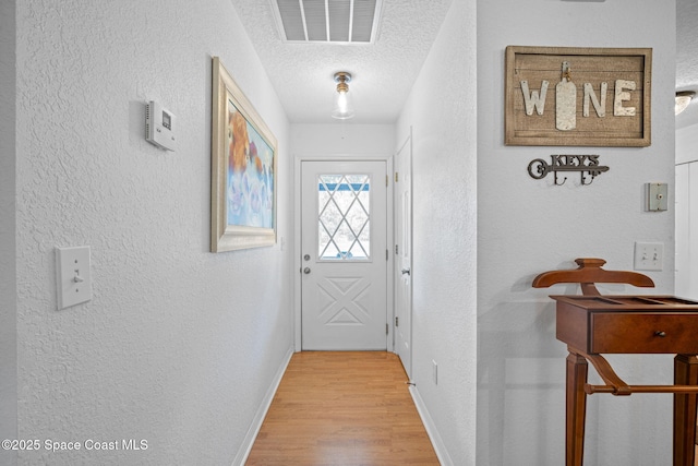 3375 Bryce St, Cocoa, FL 32926 - entryway with a textured wall, a textured ceiling, and light wood-style flooring