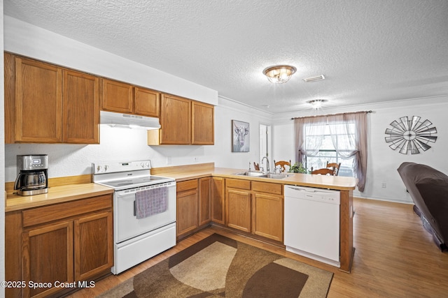 3375 Bryce St, Cocoa, FL 32926 - kitchen featuring a peninsula, white appliances, wood finished floors, light countertops, and a textured ceiling