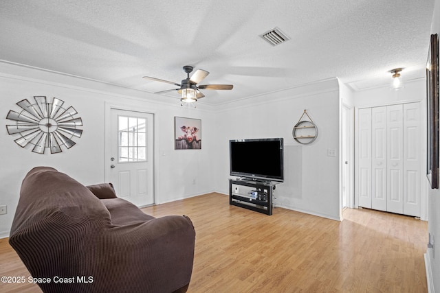 3375 Bryce St, Cocoa, FL 32926 - living room with a textured ceiling, a ceiling fan, light wood-style floors, and ornamental molding