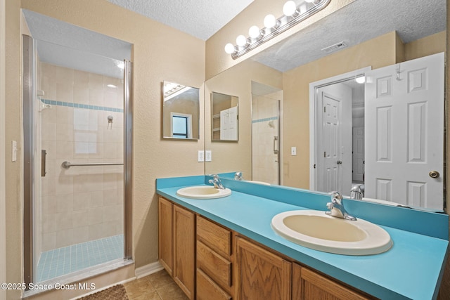 3375 Bryce St, Cocoa, FL 32926 - full bathroom with a stall shower, double vanity, a textured ceiling, and tile patterned floors