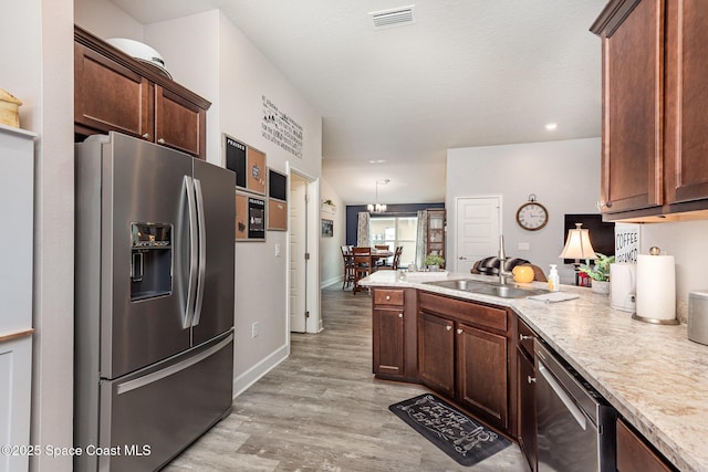 711 Tupelo Cir, Cocoa, FL 32926 - kitchen featuring stainless steel appliances, a peninsula, light countertops, light wood-style flooring, and dark brown cabinets