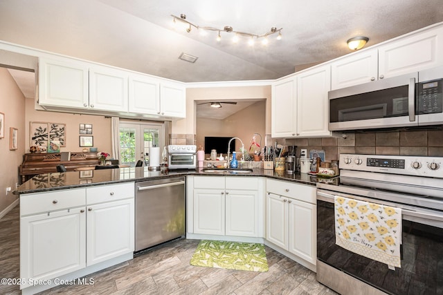 6355 Betty Ave, Cocoa, FL 32927 - kitchen with stainless steel appliances, tasteful backsplash, lofted ceiling, and white cabinetry