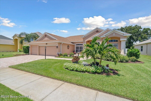 3616 Peninsula Cir, Melbourne, FL 32940 - view of front of home with decorative driveway, an attached garage, stucco siding, and a front lawn