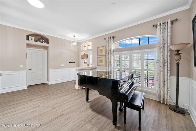 3616 Peninsula Cir, Melbourne, FL 32940 - rec room with healthy amount of natural light, light wood-style floors, wainscoting, crown molding, and a decorative wall