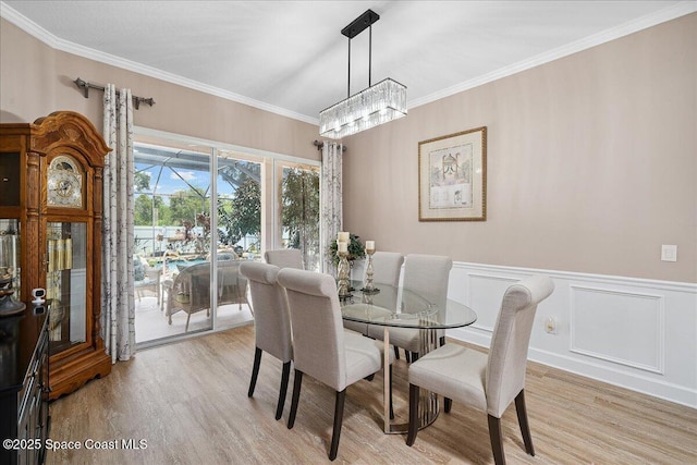 3616 Peninsula Cir, Melbourne, FL 32940 - dining room with wood finished floors, ornamental molding, a wainscoted wall, and a chandelier