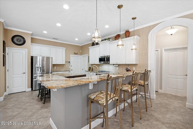 3616 Peninsula Cir, Melbourne, FL 32940 - kitchen featuring stainless steel appliances, a peninsula, a breakfast bar area, light stone counters, and tasteful backsplash