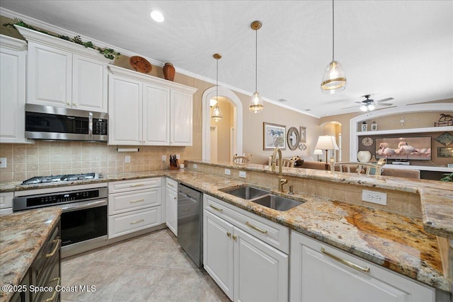 3616 Peninsula Cir, Melbourne, FL 32940 - kitchen with stainless steel appliances, arched walkways, a ceiling fan, tasteful backsplash, and white cabinetry