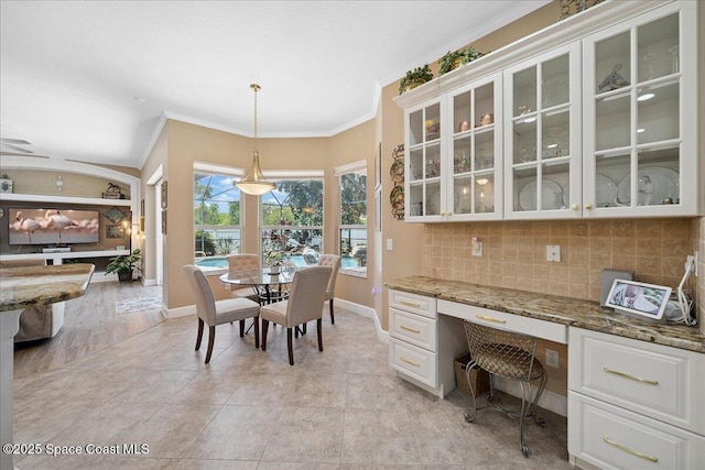 3616 Peninsula Cir, Melbourne, FL 32940 - dining space with ornamental molding, built in desk, and light tile patterned floors