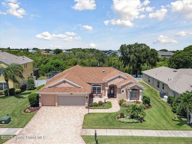 3616 Peninsula Cir, Melbourne, FL 32940 - mediterranean / spanish-style home featuring decorative driveway, stucco siding, a front yard, and an attached garage