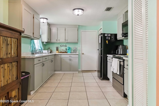 542 Troy Rd SW, Palm Bay, FL 32908 - kitchen with black appliances, light countertops, light tile patterned floors, and gray cabinetry