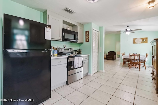 542 Troy Rd SW, Palm Bay, FL 32908 - kitchen with black appliances, light countertops, light tile patterned flooring, ceiling fan, and white cabinets