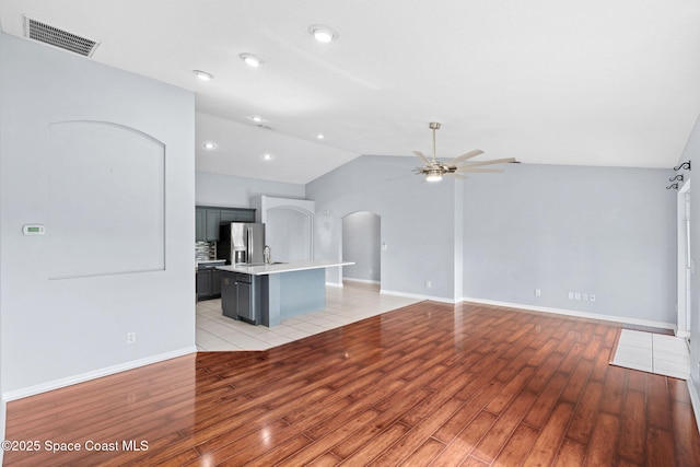 1493 Laramie Cir, Melbourne, FL 32940 - unfurnished living room featuring arched walkways, a ceiling fan, light wood-style flooring, lofted ceiling, and recessed lighting