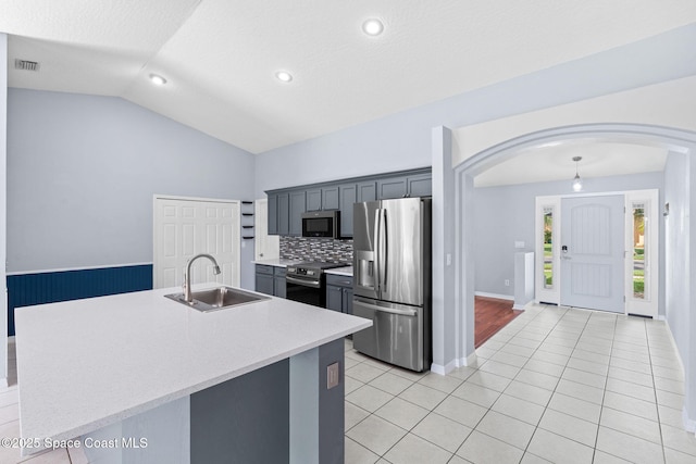 1493 Laramie Cir, Melbourne, FL 32940 - kitchen with appliances with stainless steel finishes, arched walkways, vaulted ceiling, light countertops, and light tile patterned floors