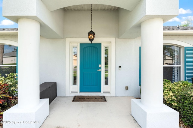 1493 Laramie Cir, Melbourne, FL 32940 - view of exterior entry with stucco siding, covered porch, and roof with shingles