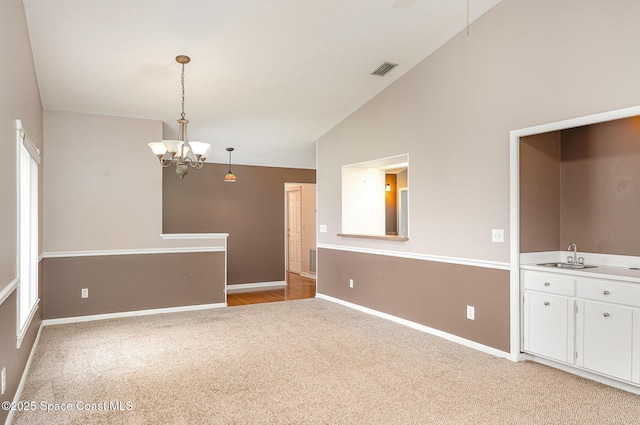 386 Myrtlewood Rd, Melbourne, FL 32940 - spare room featuring light carpet, lofted ceiling, and a chandelier