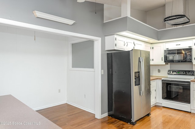 386 Myrtlewood Rd, Melbourne, FL 32940 - kitchen with range with electric stovetop, stainless steel fridge, light wood-style flooring, black microwave, and tasteful backsplash