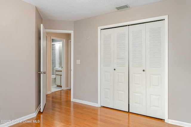 386 Myrtlewood Rd, Melbourne, FL 32940 - unfurnished bedroom featuring a closet, light wood finished floors, and a textured ceiling