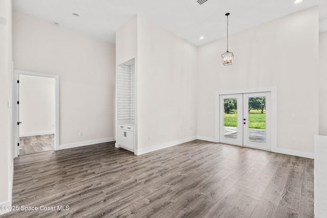 278 Stallion St, Palm Bay, FL 32909 - empty room featuring a high ceiling, french doors, wood finished floors, a chandelier, and recessed lighting