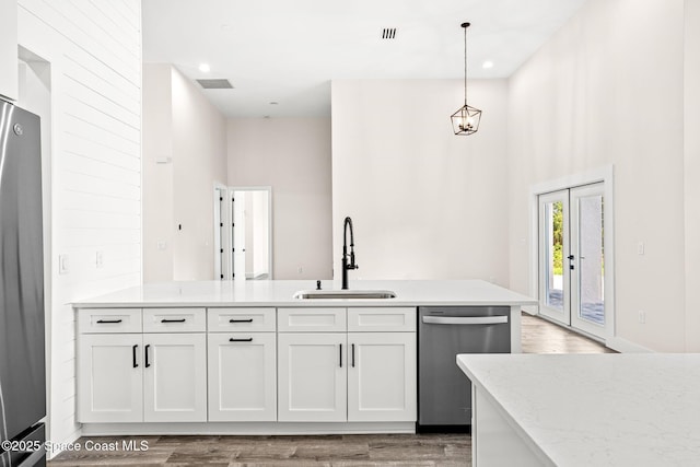 278 Stallion St, Palm Bay, FL 32909 - kitchen featuring stainless steel appliances, light wood finished floors, white cabinets, pendant lighting, and light stone countertops
