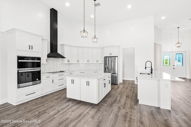 278 Stallion St, Palm Bay, FL 32909 - kitchen with black appliances, a center island, a high ceiling, wall chimney range hood, and tasteful backsplash