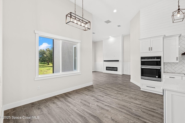 278 Stallion St, Palm Bay, FL 32909 - kitchen featuring stainless steel double oven, a high ceiling, decorative light fixtures, tasteful backsplash, and white cabinetry