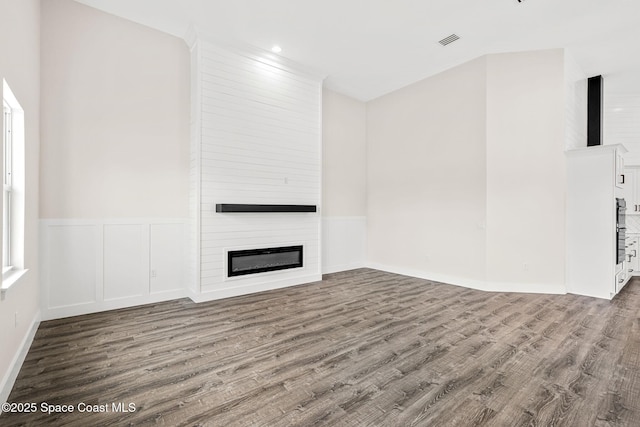 278 Stallion St, Palm Bay, FL 32909 - unfurnished living room featuring wood finished floors, a large fireplace, wainscoting, and recessed lighting