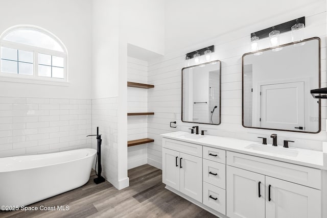 278 Stallion St, Palm Bay, FL 32909 - full bath featuring double vanity, a freestanding tub, tile walls, wood finished floors, and a wainscoted wall