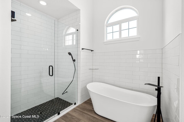 278 Stallion St, Palm Bay, FL 32909 - full bathroom featuring tile walls, a soaking tub, wood finished floors, a shower stall, and recessed lighting