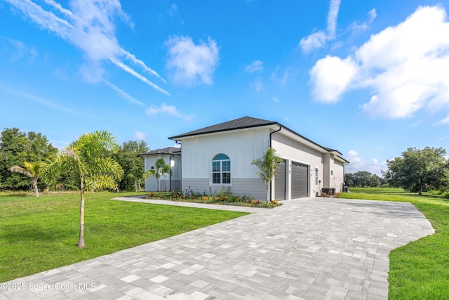 278 Stallion St, Palm Bay, FL 32909 - view of front of home featuring decorative driveway, a garage, a front lawn, and board and batten siding