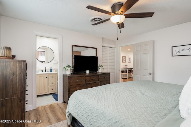 560 Conifer St, Melbourne, FL 32904 - bedroom featuring light wood-type flooring, ensuite bath, and a ceiling fan