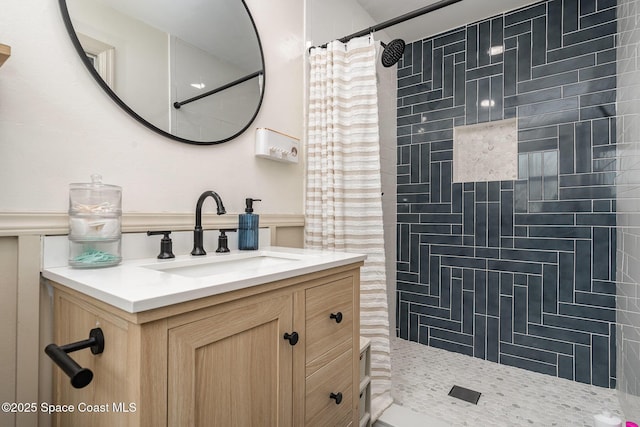 560 Conifer St, Melbourne, FL 32904 - bathroom featuring tiled shower, vanity, and a wainscoted wall