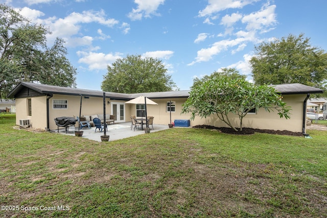 560 Conifer St, Melbourne, FL 32904 - back of property with a yard, stucco siding, and a patio