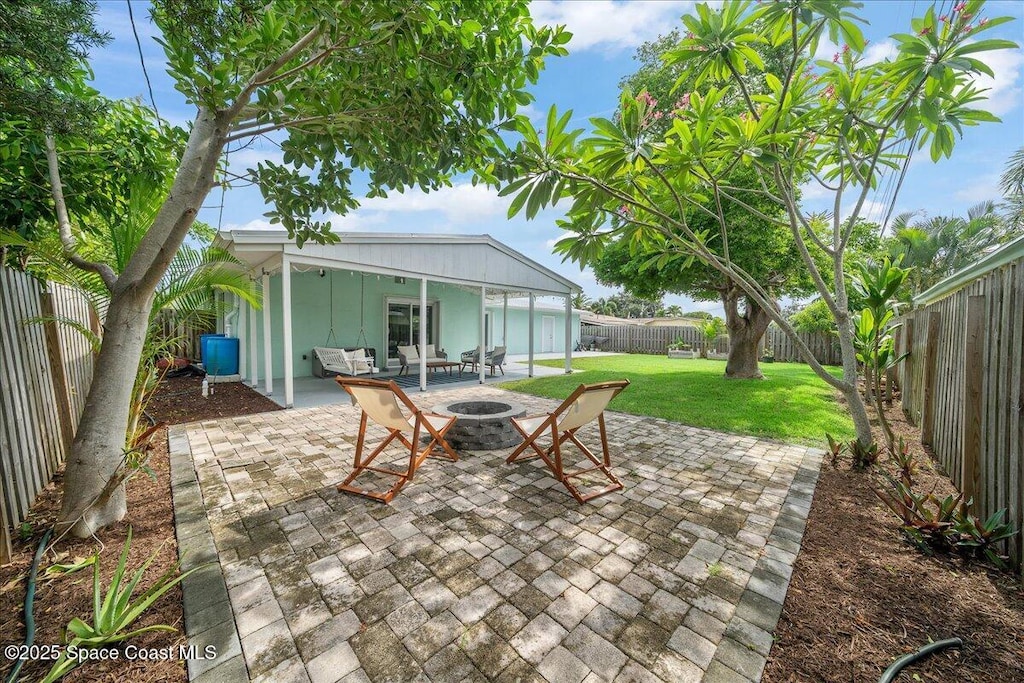 221 Timpoochee Dr, Indian Harbour Beach, FL 32937 - fenced backyard featuring a patio and an outdoor living space with a fire pit