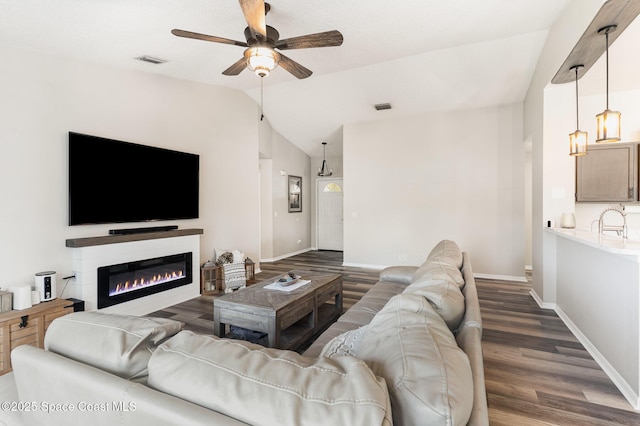 1519 Bronco Dr, Melbourne, FL 32940 - living room with vaulted ceiling, ceiling fan, wood finished floors, and a glass covered fireplace