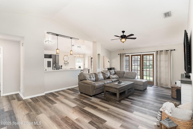1519 Bronco Dr, Melbourne, FL 32940 - living area with a ceiling fan, wood finished floors, vaulted ceiling, french doors, and a chandelier