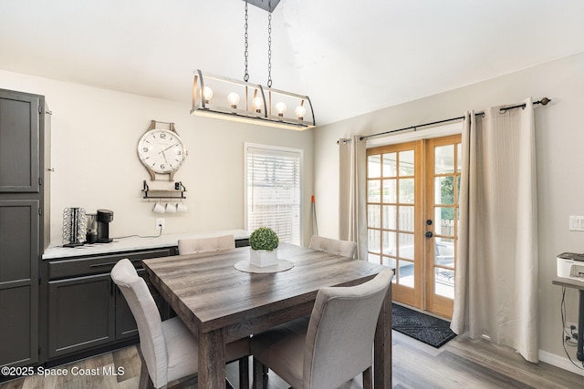 1519 Bronco Dr, Melbourne, FL 32940 - dining space with french doors, light wood-type flooring, and vaulted ceiling