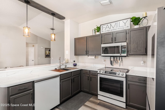 1519 Bronco Dr, Melbourne, FL 32940 - kitchen with stainless steel appliances, lofted ceiling, a peninsula, light wood-type flooring, and decorative light fixtures