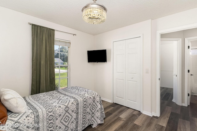 1519 Bronco Dr, Melbourne, FL 32940 - bedroom with dark wood finished floors, a closet, a chandelier, and a textured ceiling