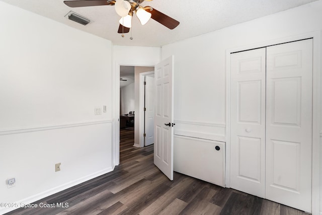 1519 Bronco Dr, Melbourne, FL 32940 - unfurnished bedroom featuring dark wood-style flooring, a closet, and ceiling fan
