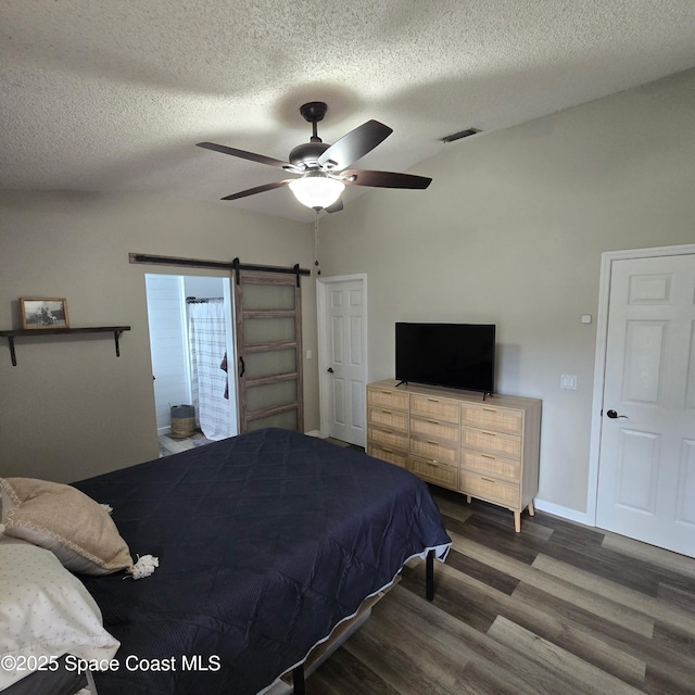 1519 Bronco Dr, Melbourne, FL 32940 - bedroom with wood finished floors, a textured ceiling, a ceiling fan, and a barn door