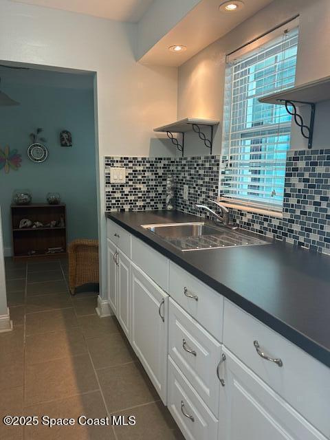 351 Taylor Ave Unit E5, Cape Canaveral, FL 32920 - kitchen featuring dark countertops, open shelves, white cabinets, backsplash, and tile patterned flooring