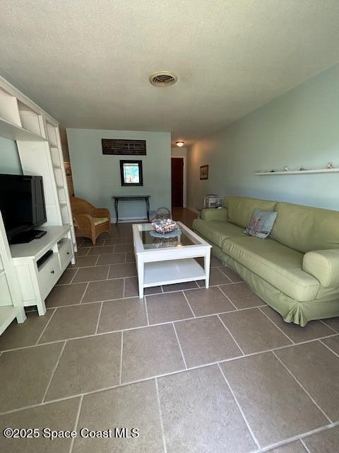 351 Taylor Ave Unit E5, Cape Canaveral, FL 32920 - living area featuring a textured ceiling and dark tile patterned flooring