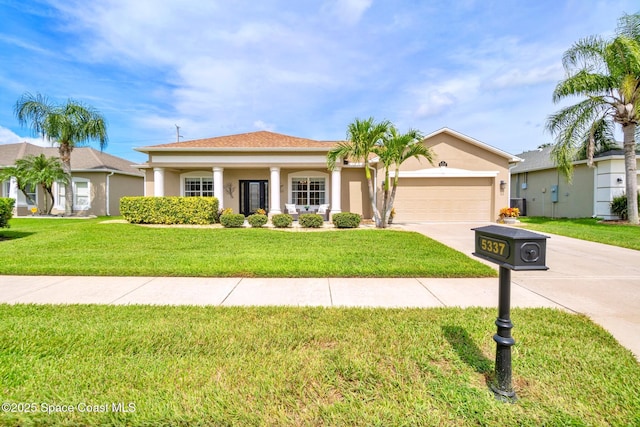 5337 Indigo Crossing Dr, Rockledge, FL 32955 - ranch-style house with concrete driveway, a garage, a front lawn, and stucco siding