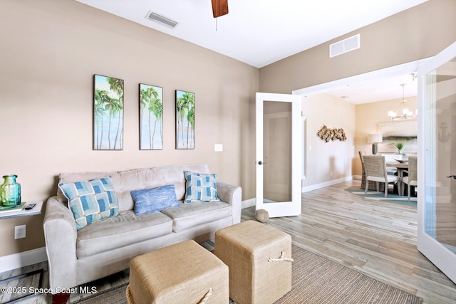 5337 Indigo Crossing Dr, Rockledge, FL 32955 - living room with french doors, wood finished floors, a ceiling fan, and a chandelier