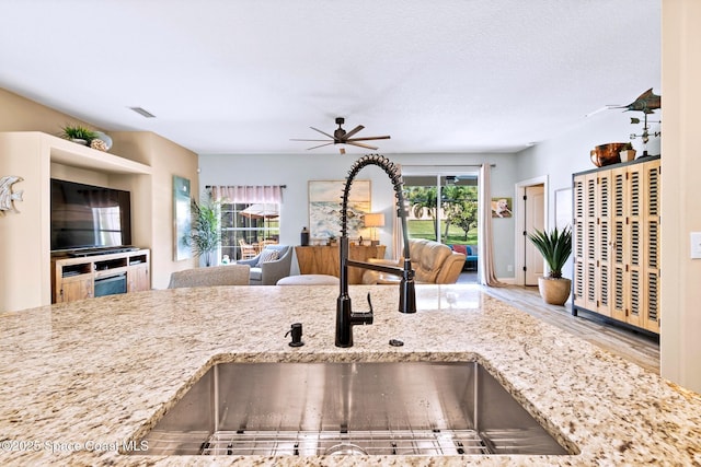 5337 Indigo Crossing Dr, Rockledge, FL 32955 - kitchen featuring ceiling fan, light stone counters, open floor plan, and wood finished floors
